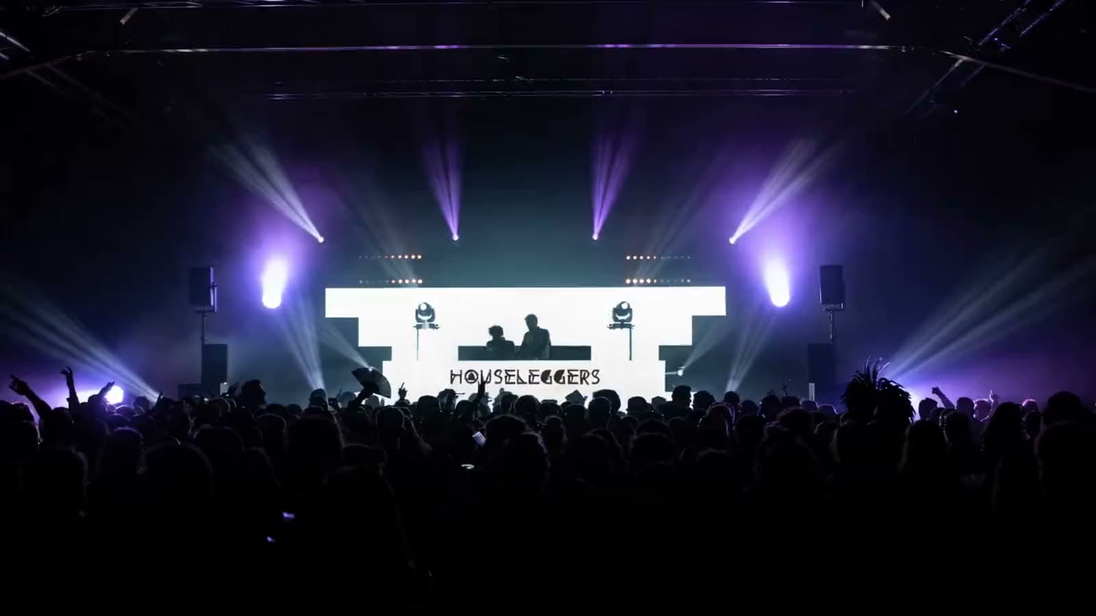 Houseleggers aux platines sur une scène LED géante devant la foule d'un festival